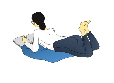 うつ伏せで本を読む女性